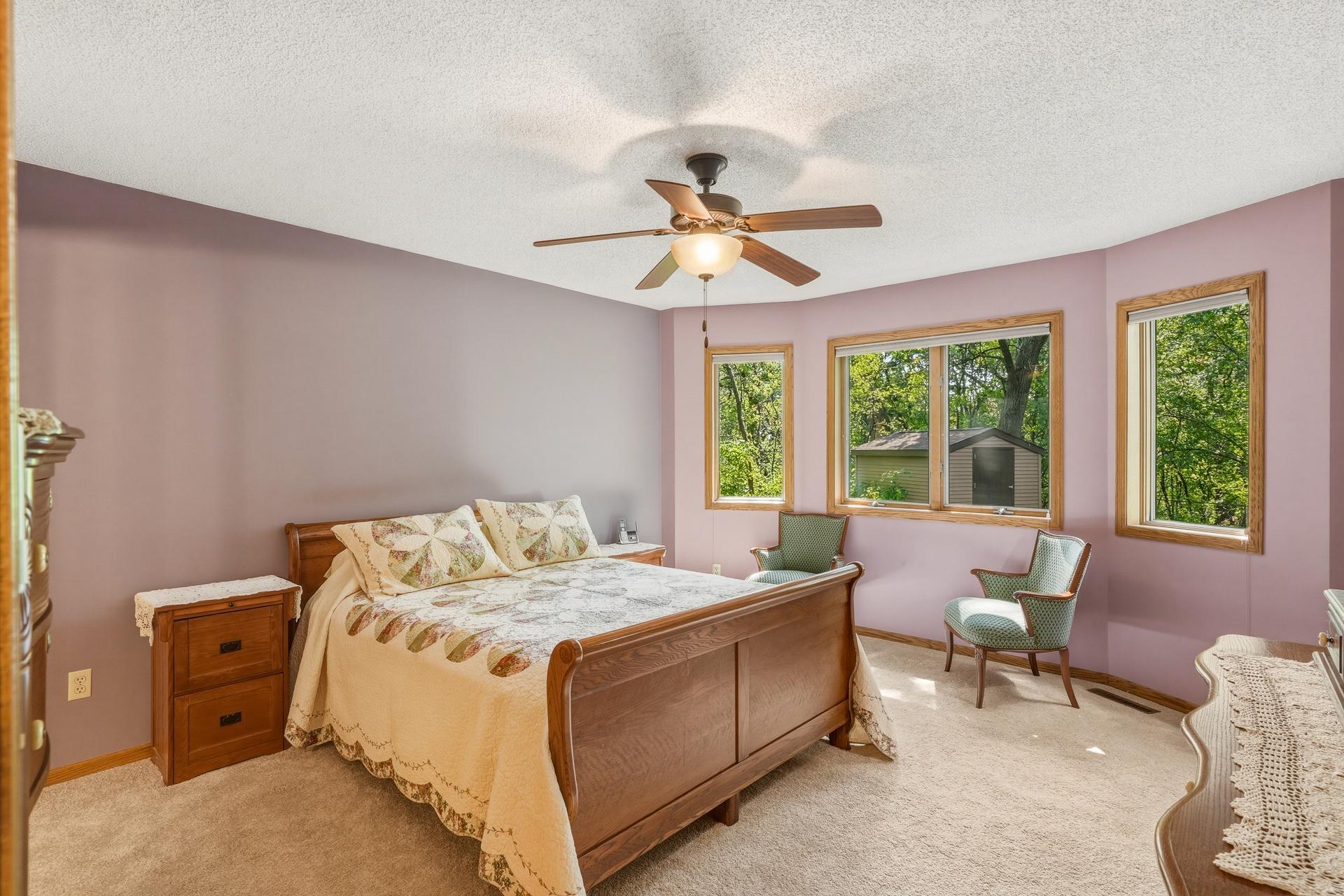Spacious Main-Level Primary Bedroom Features Abundant Natural Light, Peaceful Views of the Backyard, and New Carpet for a Fresh, Comfortable Feel