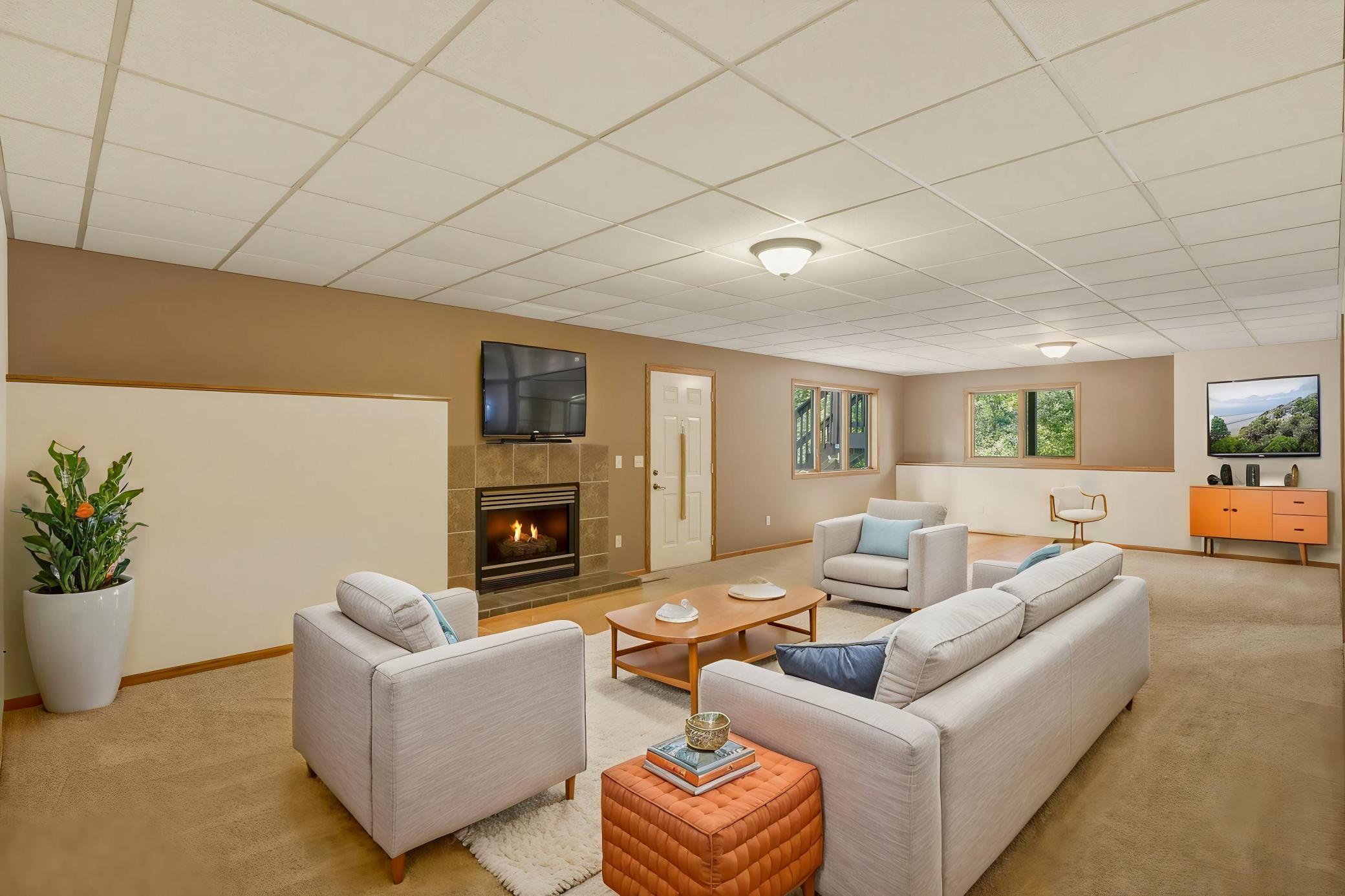 *Virtual Staged Lower-Level Living Room* The Expansive Finished Lower-Level Living Room Offers Plenty of Space to Relax and Entertain, Complete with a 2nd Gas Fireplace and Convenient Walk-Out Access to the Rear Patio and Backyard