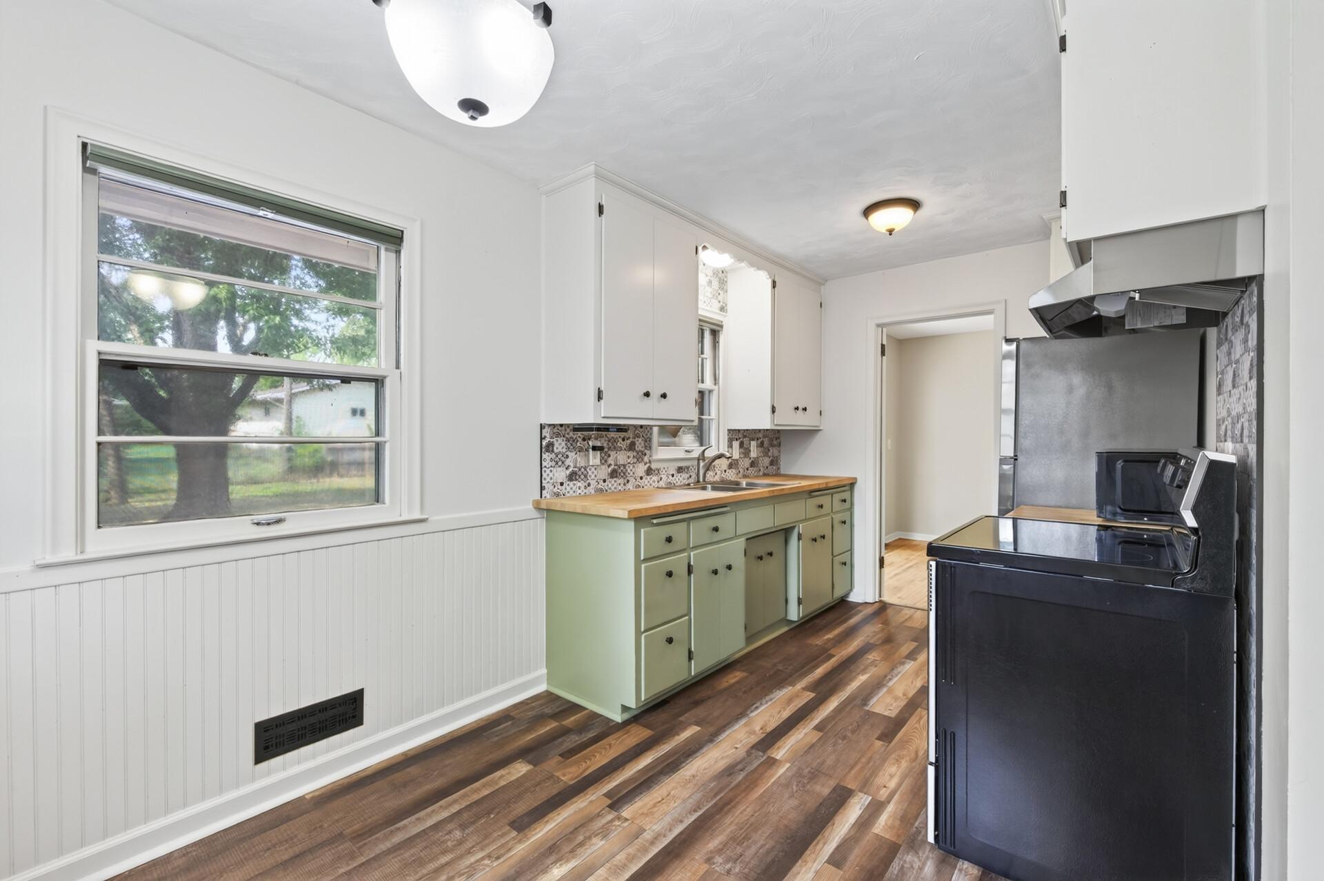 Lots of windows, handy butcherblock countertop and two tone cabinets.