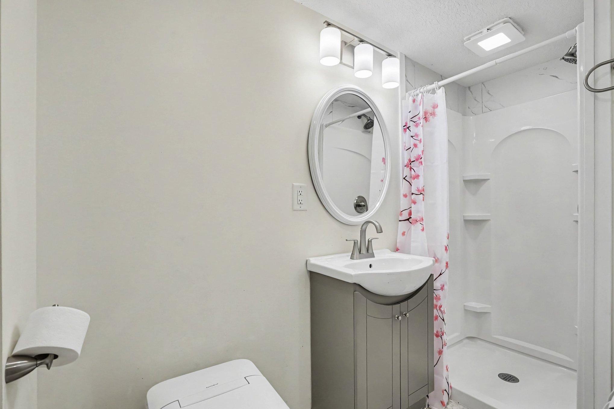 Lower Level Bathroom with new vanity, shower, toilet and flooring.
