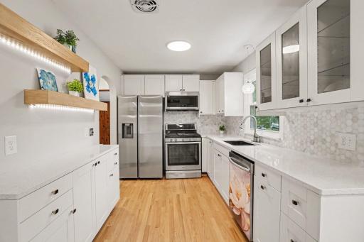 Updated Kitchen with new backsplash, cabinets, quartz countertops and lighting.