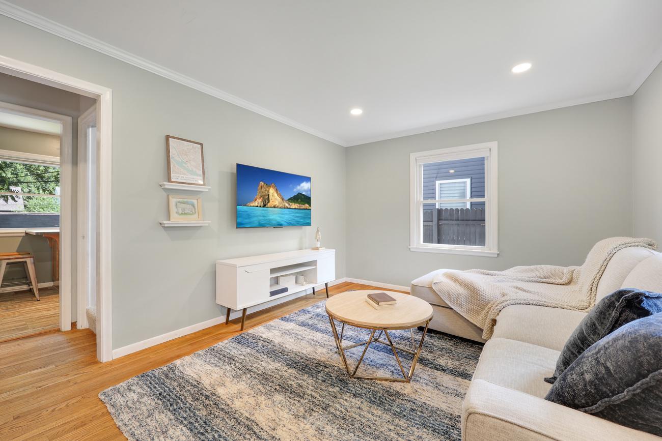 Bright and inviting living room with hardwood floors and recessed lighting.