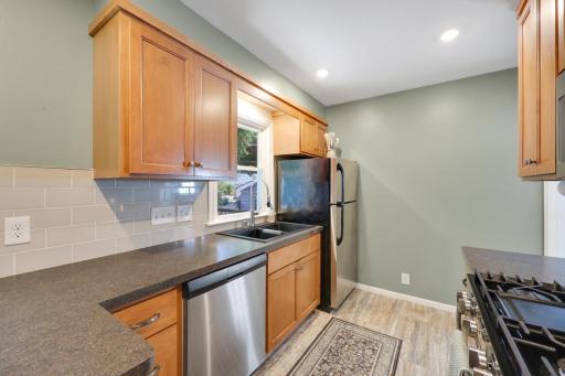 Kitchen features updated countertops, tile backsplash, and stainless steel appliances.