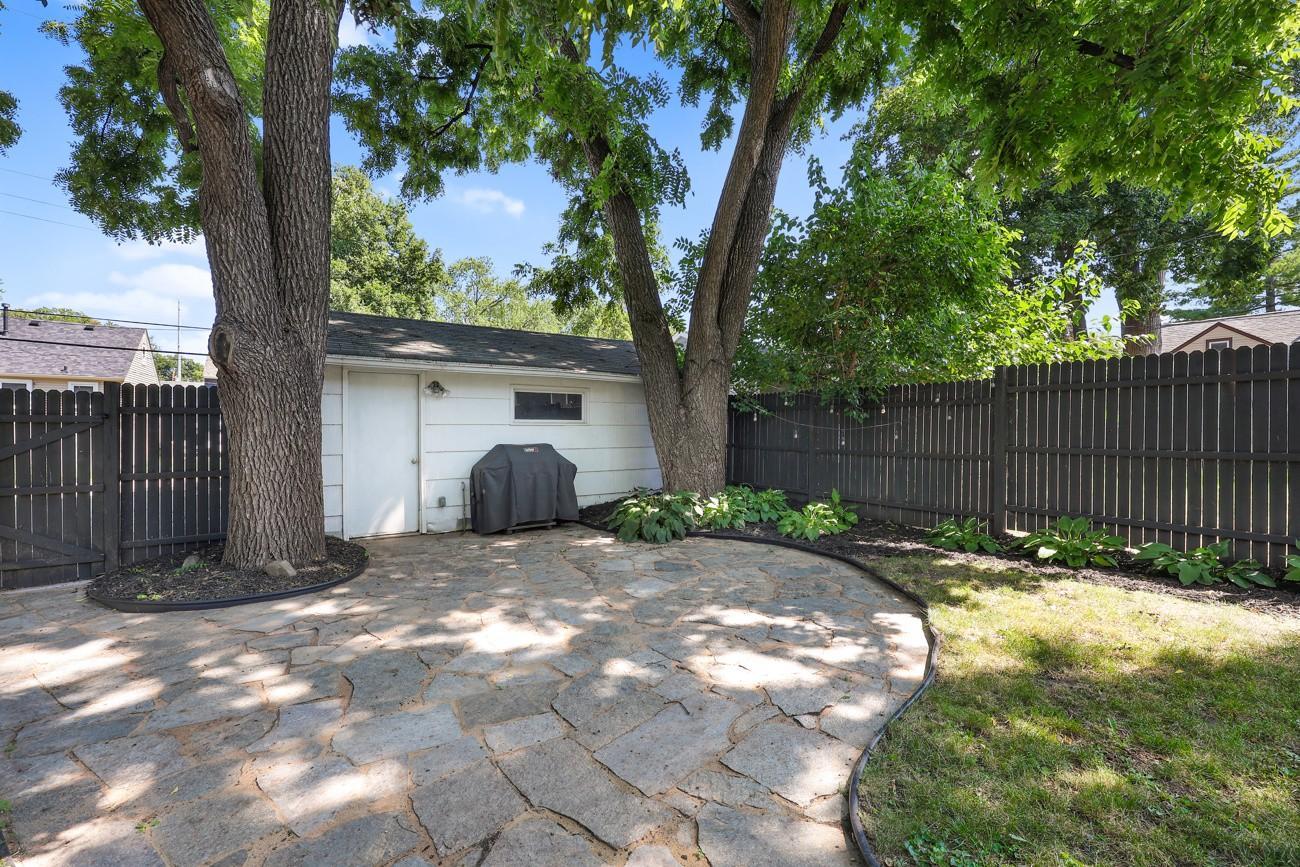 Beautiful flagstone patio leads to the detached garage and offers a view of the fully fenced yard