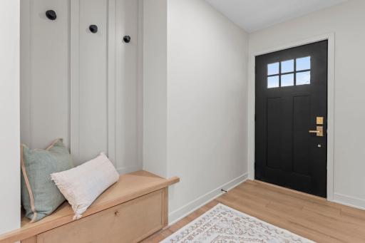 An organized entry drop zone provides bench seating, storage, and hooks, creating the perfect place to keep daily essentials neatly tucked away. A dedicated mudroom with garage access further enhances functionality with additional storage options.
