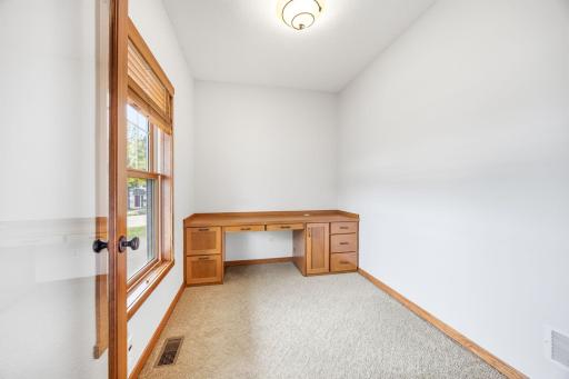 Main floor office/flex space with built in desk.