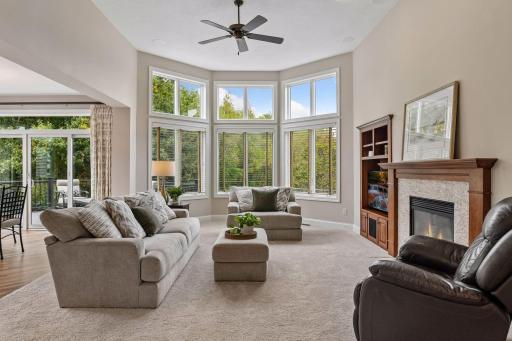 Walls of windows, a gas fireplace, and custom built-in create a light-filled gathering space designed for both everyday living and entertaining.
