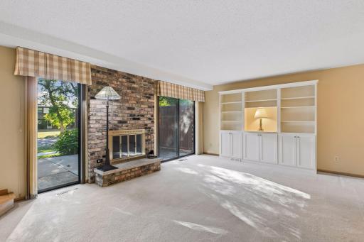 Main Floor Living Room with Brick Fireplace and Built-in Cabinetry