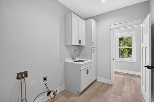 Upper level Laundry area with utility sink and tons of storage space!