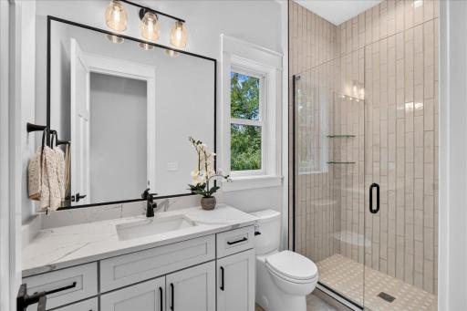 This private 3/4 bathroom is located off of the main level bedroom. Check out that tile work!