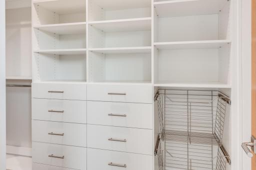 The owner's suite features a large walk in closet with custom shelves
