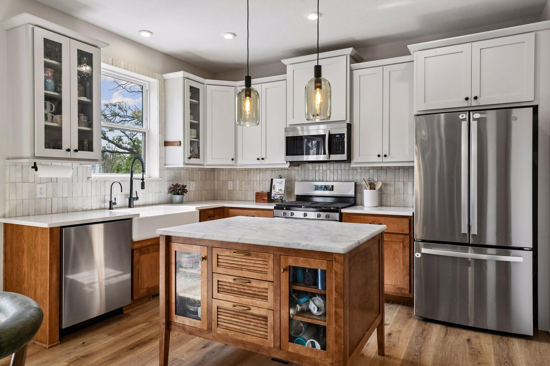 Kitchen includes custom built center island, farmhouse sink, and pendant lighting