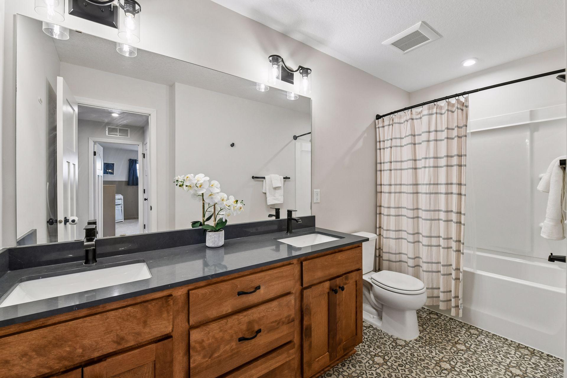 Full bath with double vanity and tub shower combination