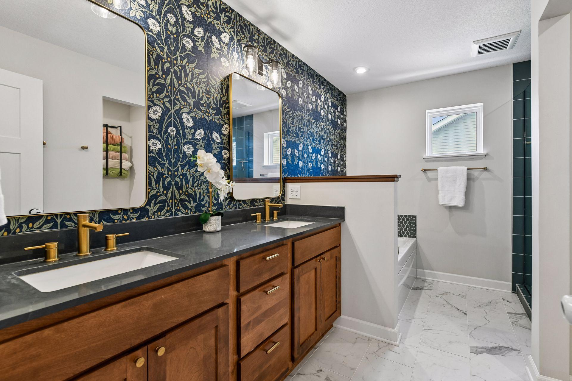 Primary bathroom with dual vanities, wallpaper, soaking tub and walk in shower