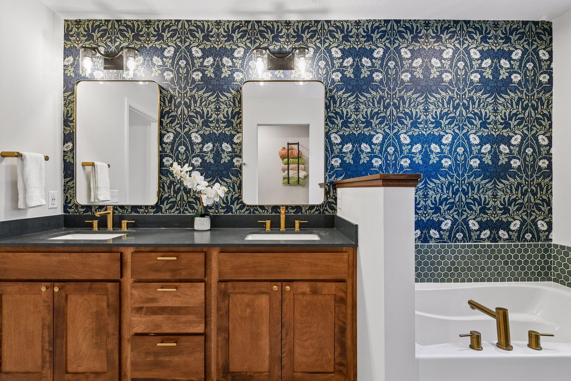Primary bathroom with dual vanities, wallpaper, soaking tub and walk in shower
