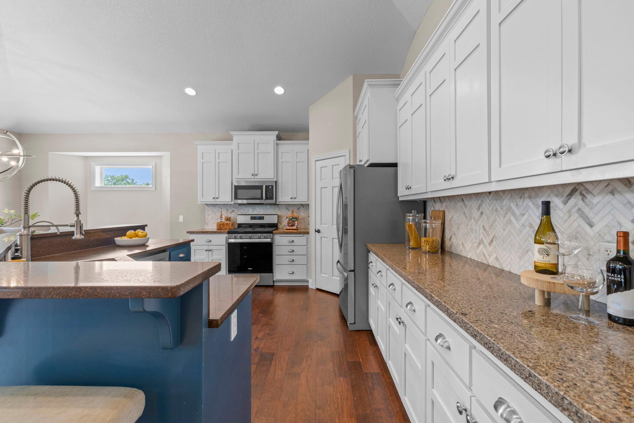 Plenty of cabinet storage pairs perfectly with granite countertops and a timeless tile backsplash.