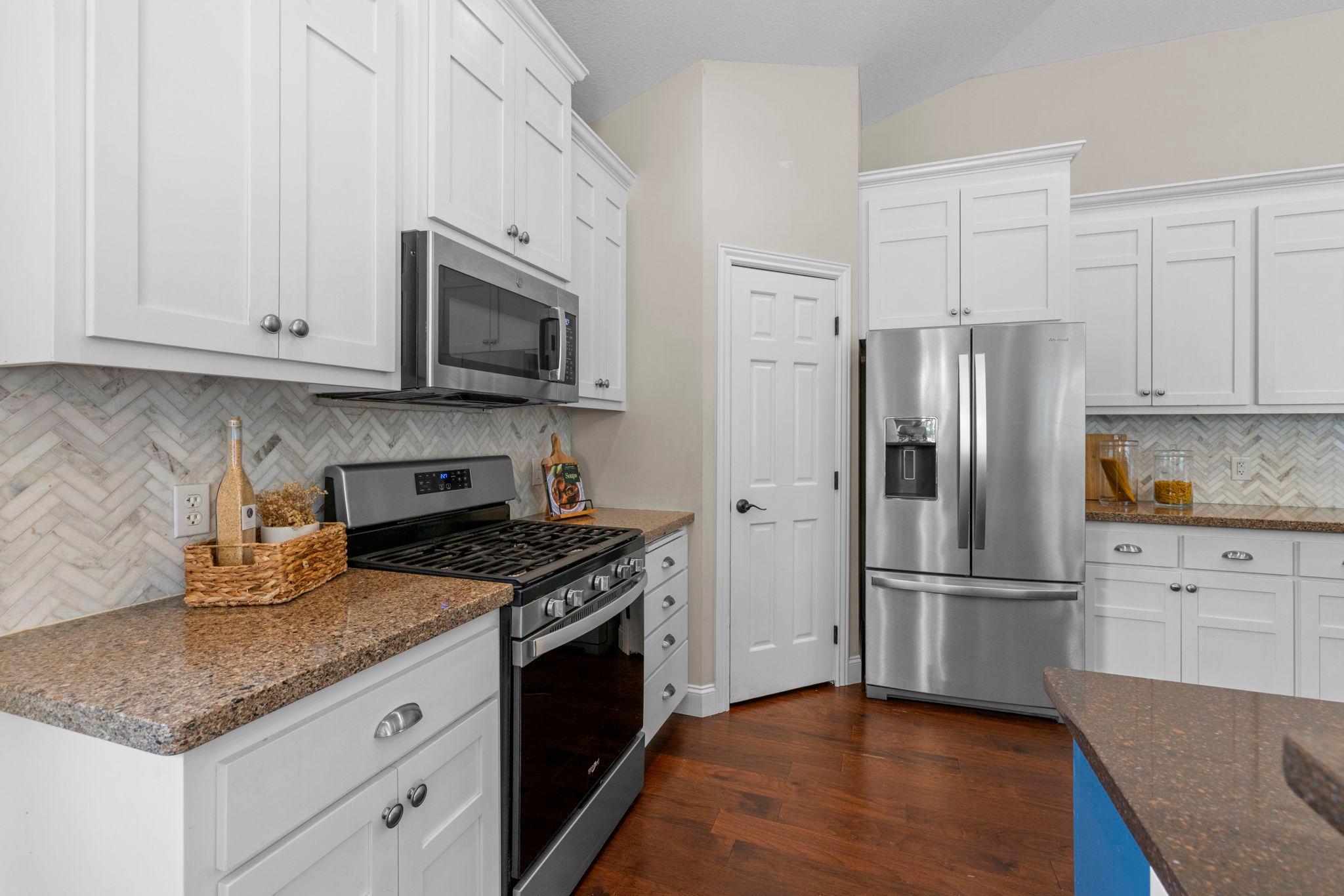 Stainless steel appliances highligted by a gas stove, in addtion to the spacious walk in pantry