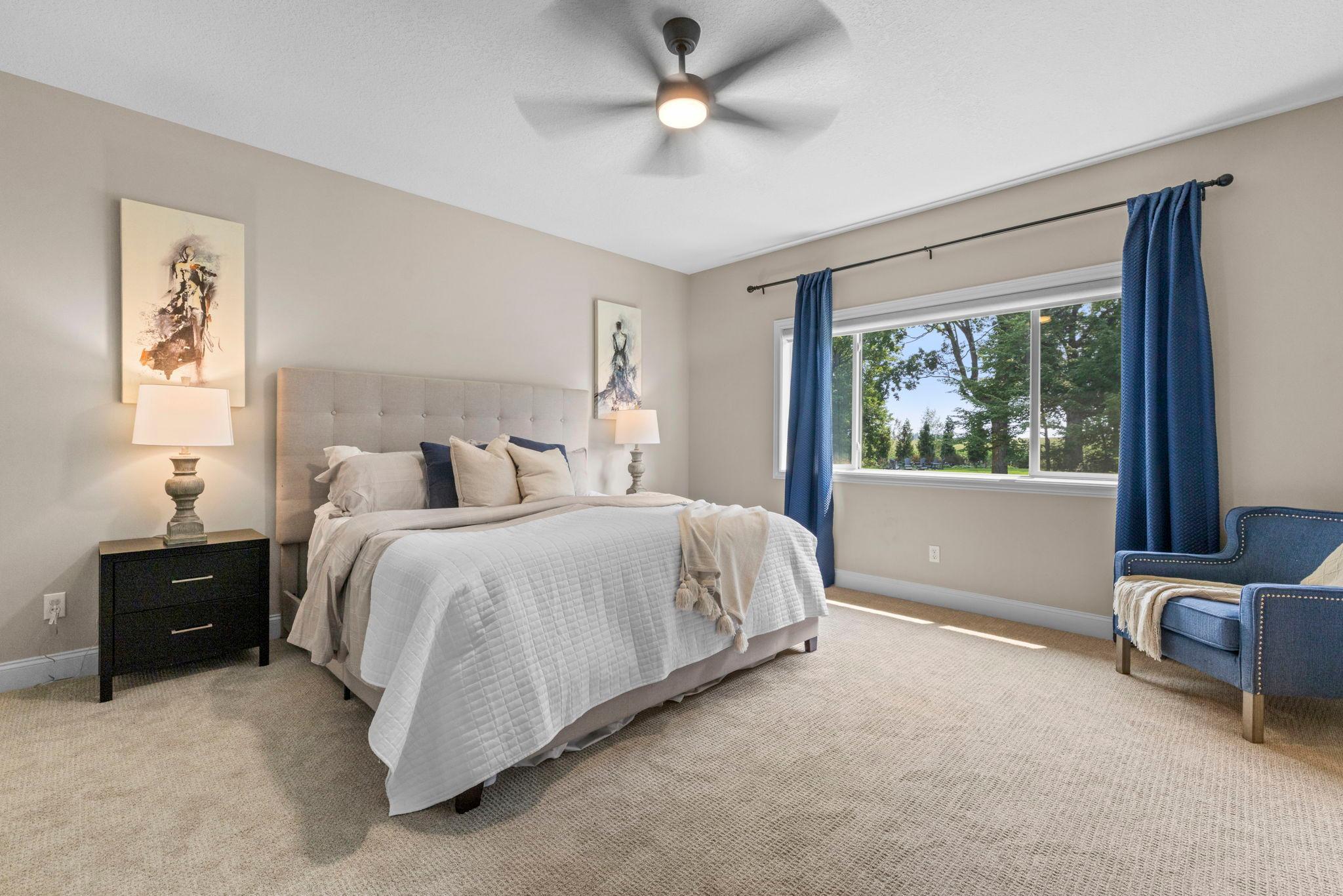 Main-level primary suite featuring new carpet (2026) and peaceful backyard views.