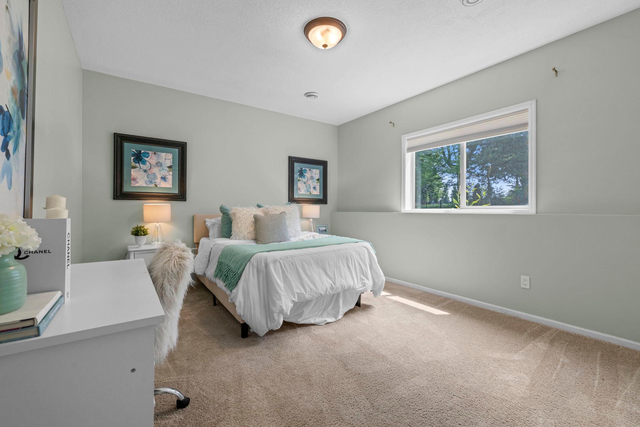 Third bedroom on the lower level with backyard views.