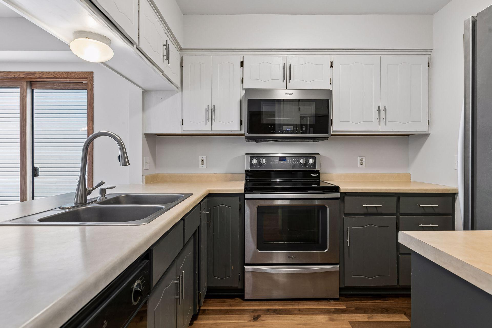 Functional kitchen featuring ample cabinetry, stainless steel appliances, hardwood floors, and a convenient layout that opens to the dining area