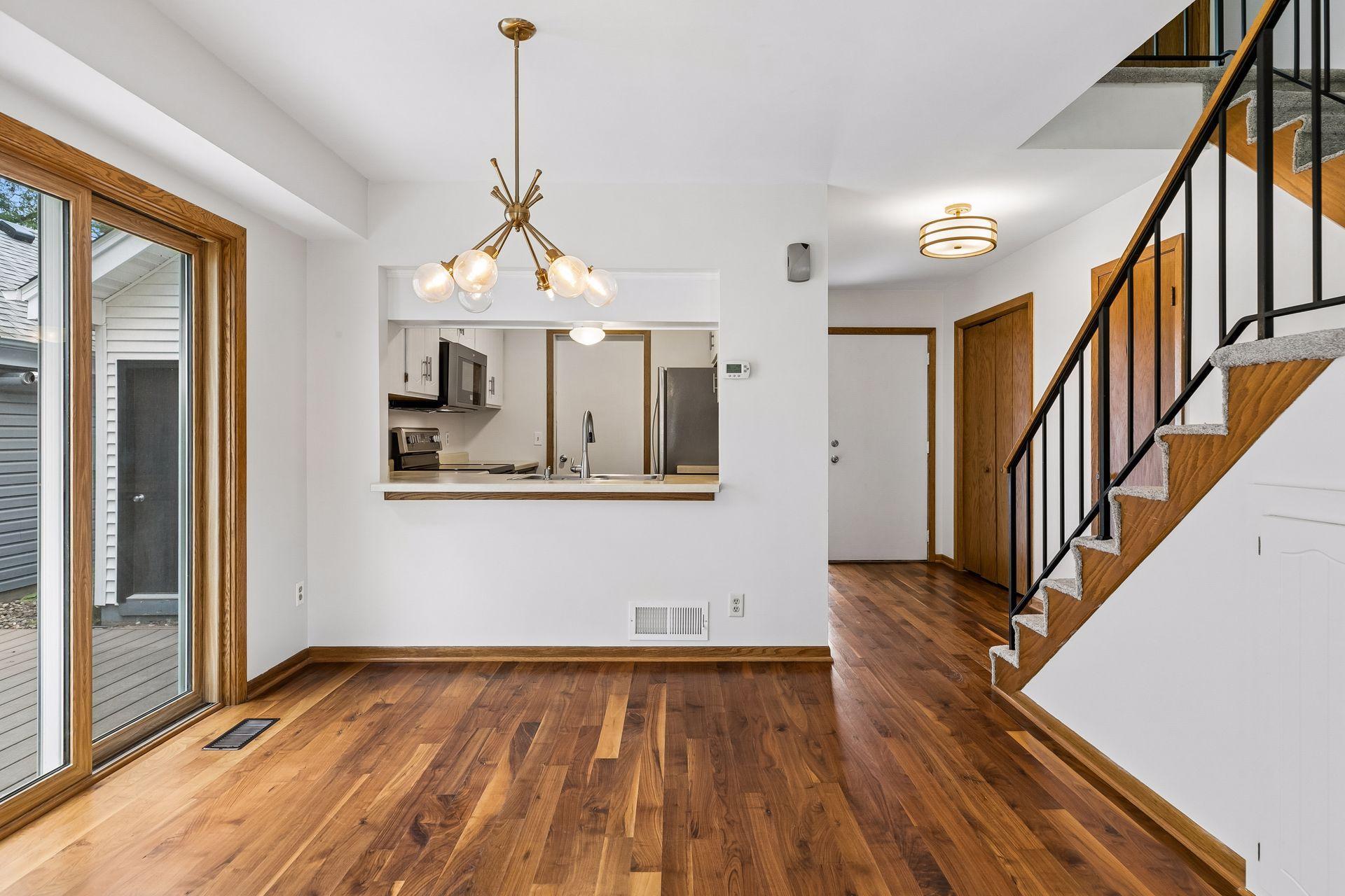 Open-concept main level with hardwood floors throughout and an easy flow from the dining area into the kitchen. Note the trendy lighting too!