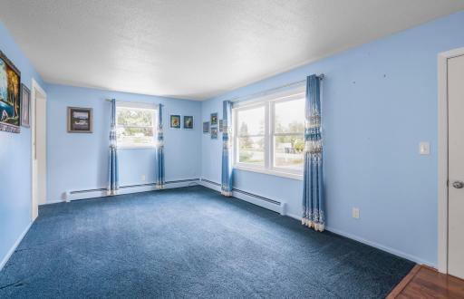 Spacious living room with large windows bringing in plenty of natural light and views of the yard.