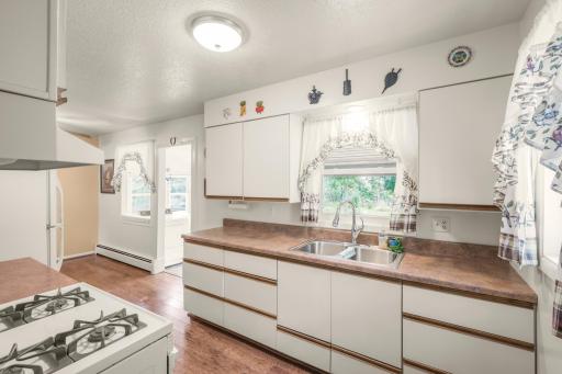 Bright kitchen with plenty of cabinet and counter space, double sink, and a window overlooking the yard.