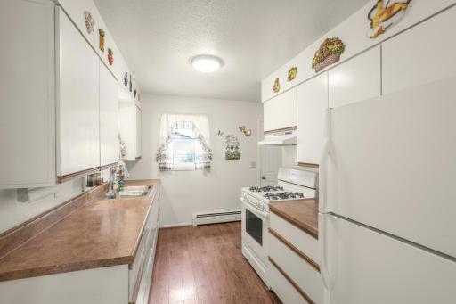 Galley-style kitchen keeps everything within easy reach while offering generous cabinetry, counter space, and natural light.