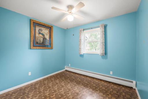 Main-level bedroom with a ceiling fan and natural light, offering flexibility for a sleeping space, an office, or a hobby room.