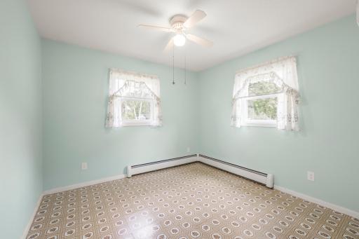 Another light-filled corner bedroom with two windows, a ceiling fan, and plenty of opportunity to make the space your own.