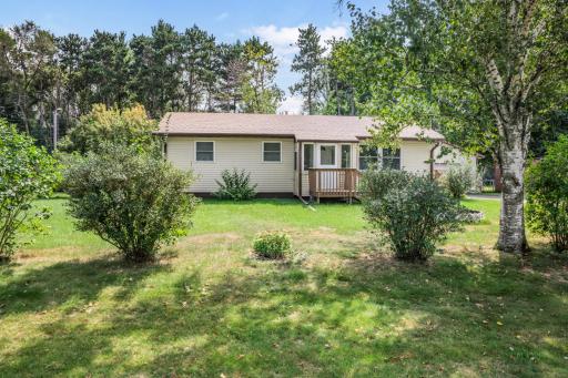 A wider view highlights the home's spacious yard, mature trees, and peaceful neighborhood setting.