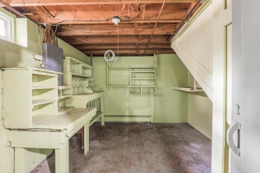Dedicated workshop area with built-in workbenches and shelving, ready for tools, projects, hobbies and additional storage.