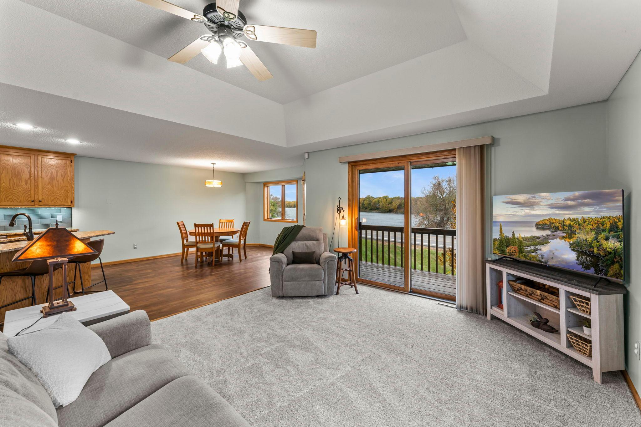 The living room features plush carpeting and a coved ceiling with ceiling fan for year-round comfort.