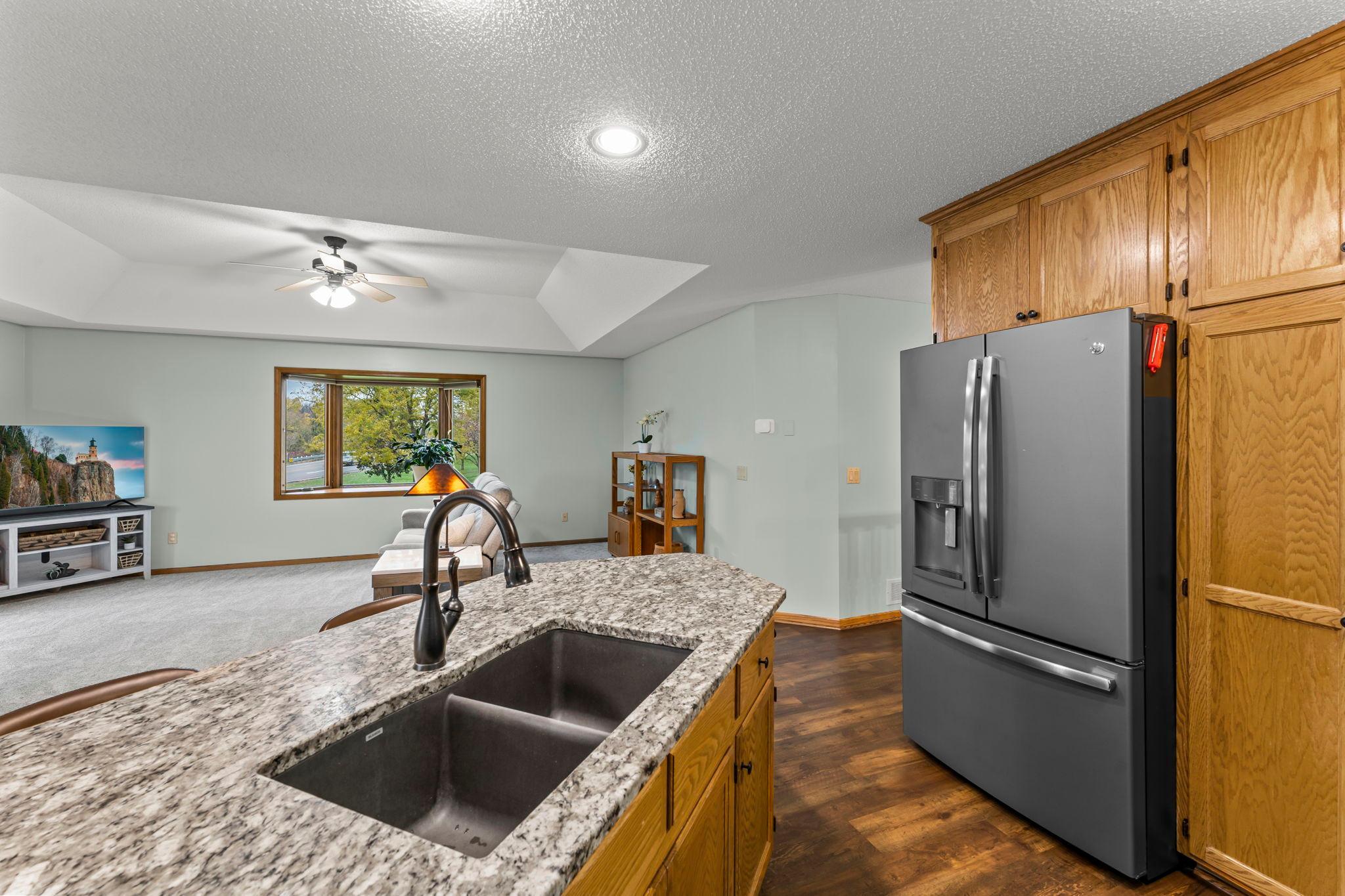 Stainless steel appliances, under-cabinet lighting, and a tile backsplash.