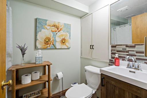 The lower-level ¾ bathroom adds convenience with a step-in shower, updated vanity, tile backsplash and built-in cabinetry for extra storage.