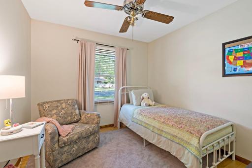 This main-level bedroom offers a comfortable layout with original hardwood flooring, a ceiling fan and a window providing natural light from the front yard. Plenty of space allows for flexible furniture placement.