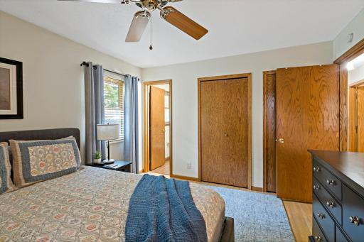 This view of the primary bedroom highlights the convenient access to the private ensuite bathroom, along with two separate closets offering plenty of space for clothing and storage.