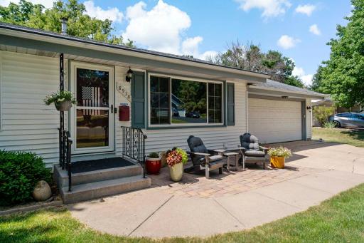 A closer look at the welcoming front entry showcases a paver patio with space for seating and colorful planters—creating an inviting spot to enjoy the outdoors and your neighborhood.