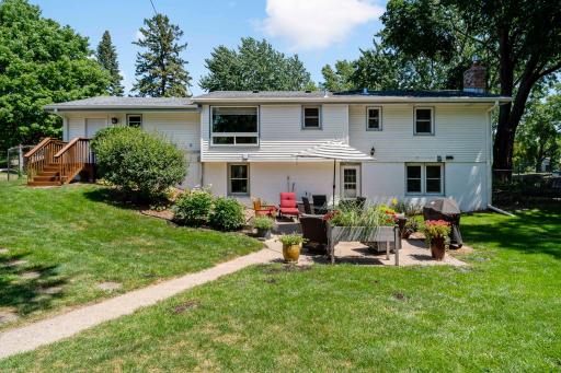 The backyard offers a welcoming outdoor retreat with a spacious patio perfect for dining, grilling, & entertaining. Surrounded by a lush lawn, mature trees, & established landscaping, the space provides plenty of room to relax and enjoy the outdoors.