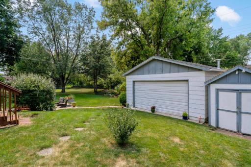 The backyard features a separate heated workshop garage as well as an adjacent storage shed providing even more functionality, all conveniently situated within the spacious, tree-lined backyard.