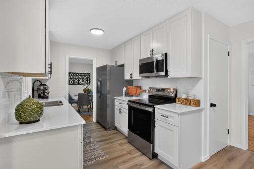 Main level: kitchen with new flooring, brand new cabinets, quartz counters, and stainless appliances