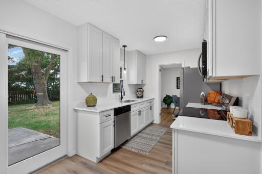 Main level: kitchen with new flooring, brand new cabinets, quartz counters, and stainless appliances