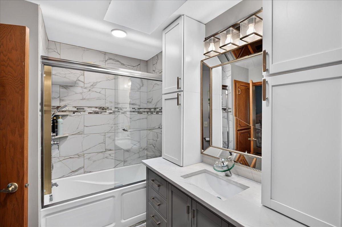 Jetted tub, tile surround, and 5-in-1 shower panel with rainfall waterfall massage jets - feels like a hotel style shower.