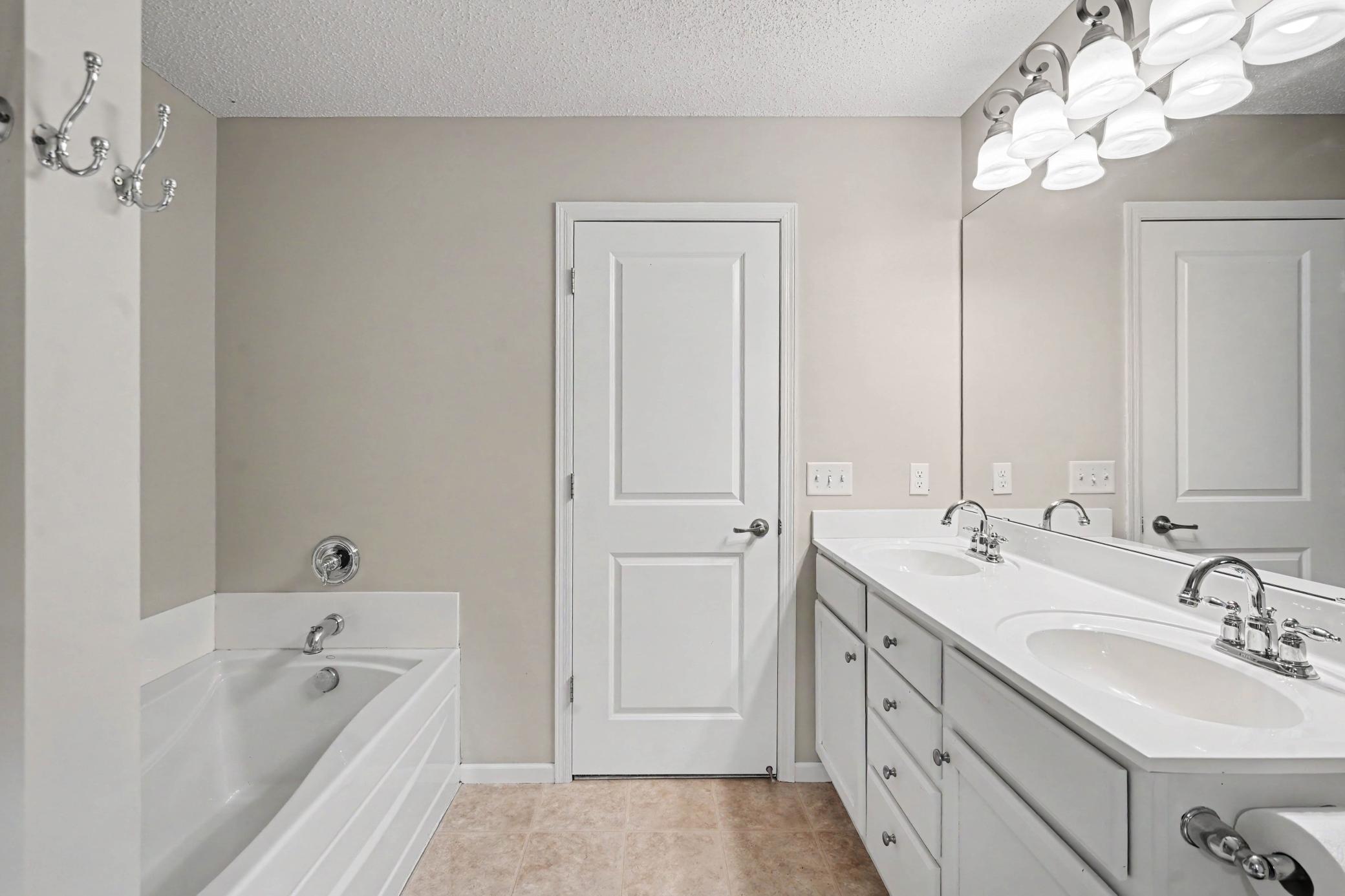 Primary Full Bathroom with dual sinks and jetted tub