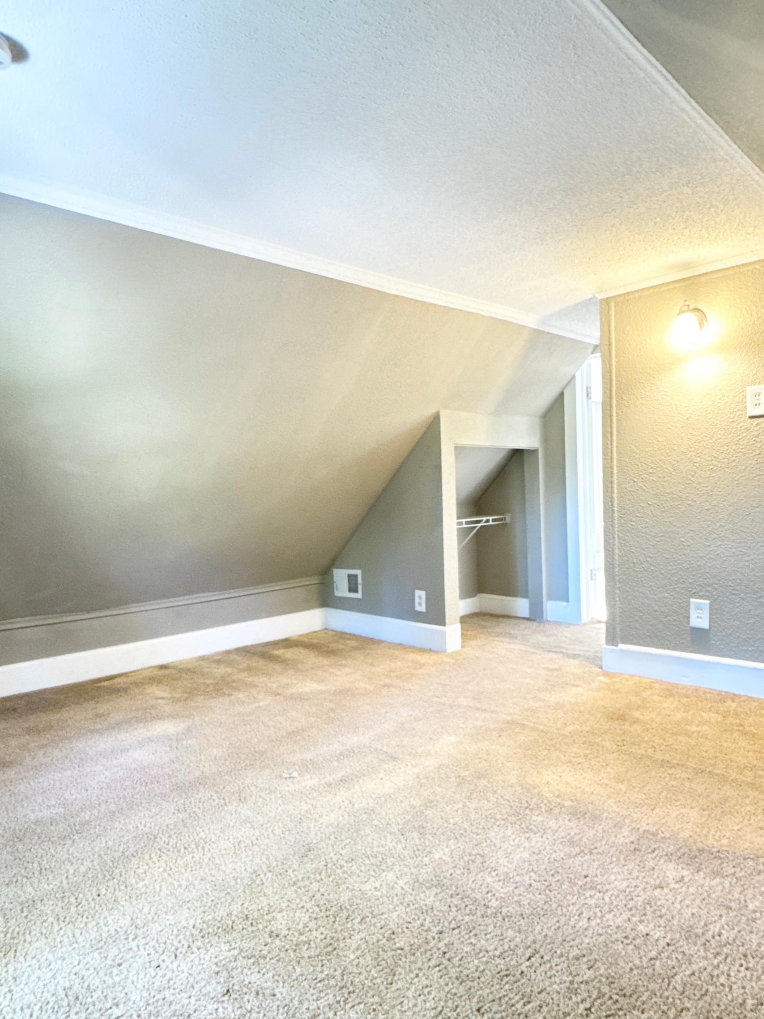 A spacious second bedroom with distinctive upper-level character.