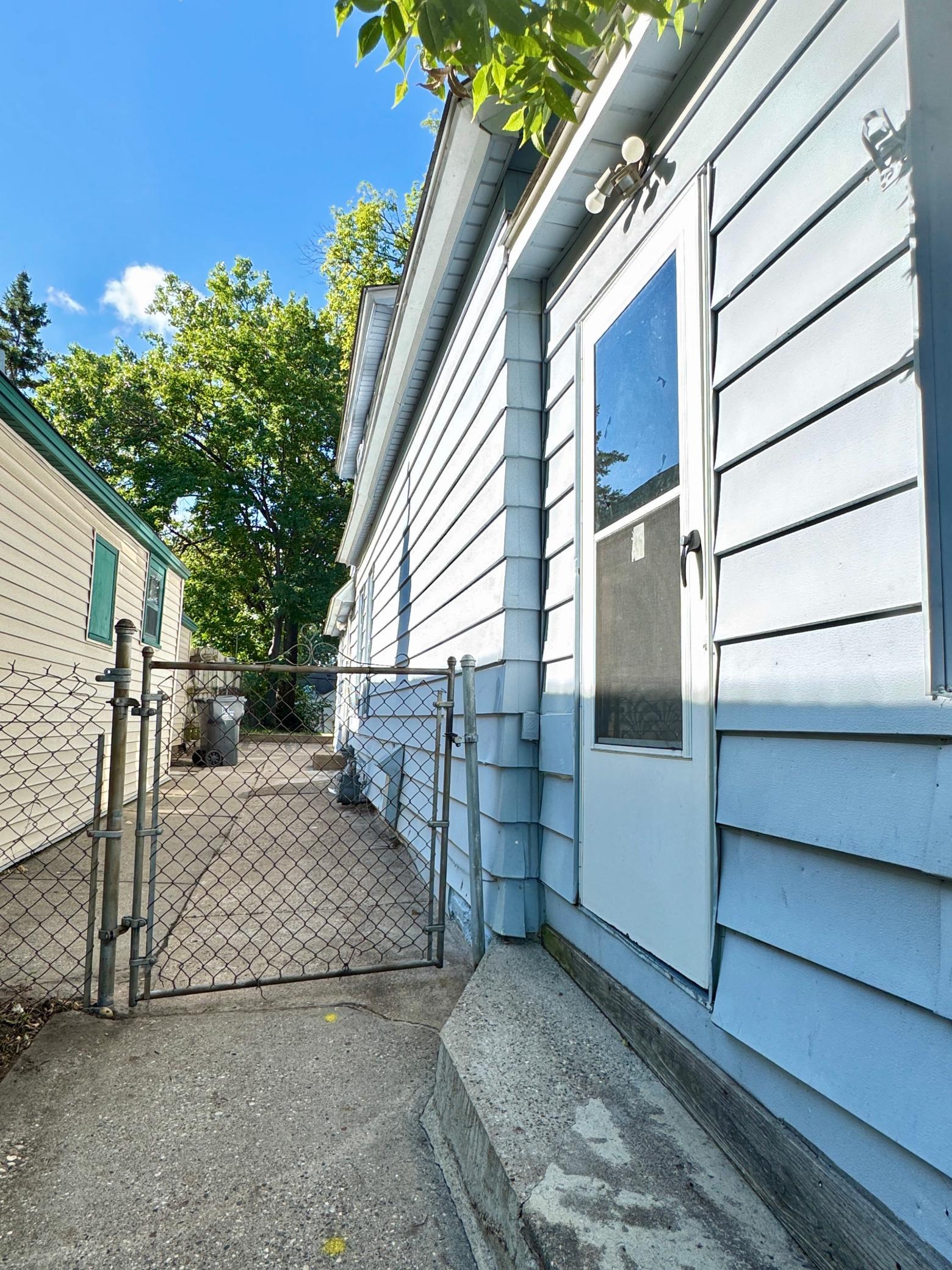 Convenient side entrance with a fenced walkway leading toward the rear of the property.