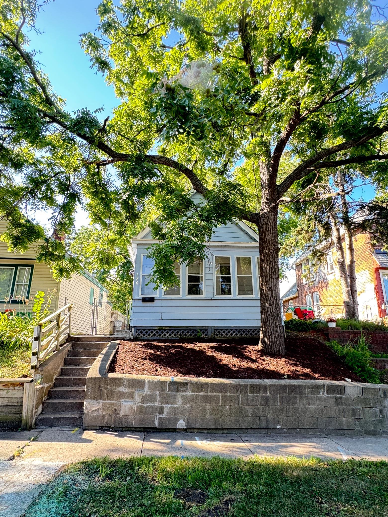 Mature trees provide shade and character along the front of the home.