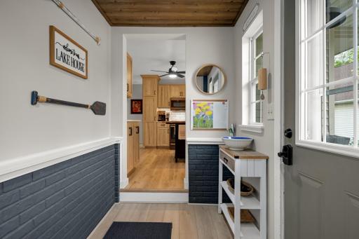 A charming foyer/mudroom featuring a refreshed closet with new flooring, shelving, and dedicated shoe storage.