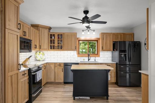 Updated kitchen featuring Cambria quartz countertops, tile backsplash, and updated sink and appliances.