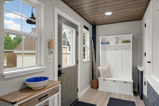 A charming foyer/mudroom featuring a refreshed closet with new flooring, shelving, and dedicated shoe storage.